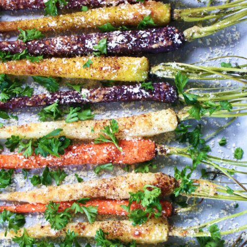 overhead shot of rainbow carrots garnished with parsley and parmesan cheese