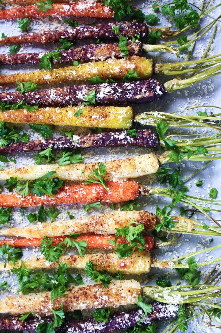 overhead shot of rainbow carrots garnished with parsley and parmesan cheese