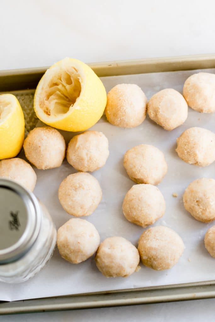 lemon bar fat bombs with lemon rinds on a baking tray
