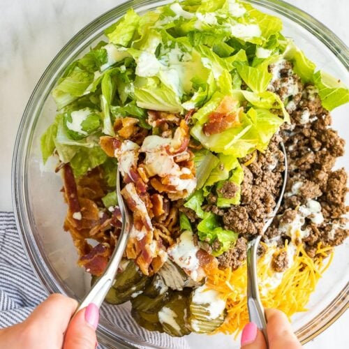 Big Mac salad being mixed in a bowl.