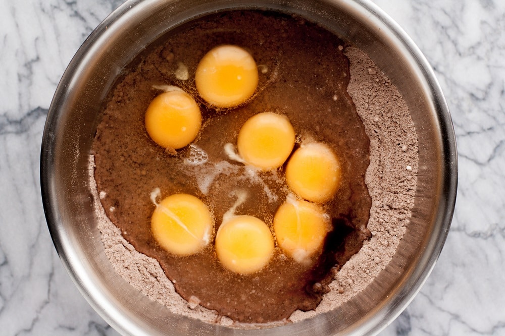 dry-ingredients-whisked-in-bowl-with-eggs-for-Low-Carb-Triple-Chocolate-Zucchini-Muffins