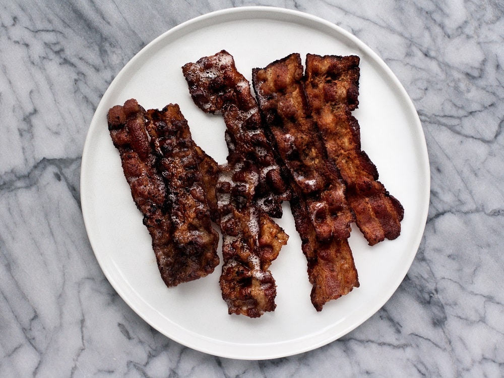 cooked-bacon-on-white-plate-on-marble-board-for-warm-bacon-and-egg-salad