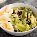 close-up-landscape-side-angle-shot-of-bowl-of-warm-bacon-and-egg-salad-on-marble-board