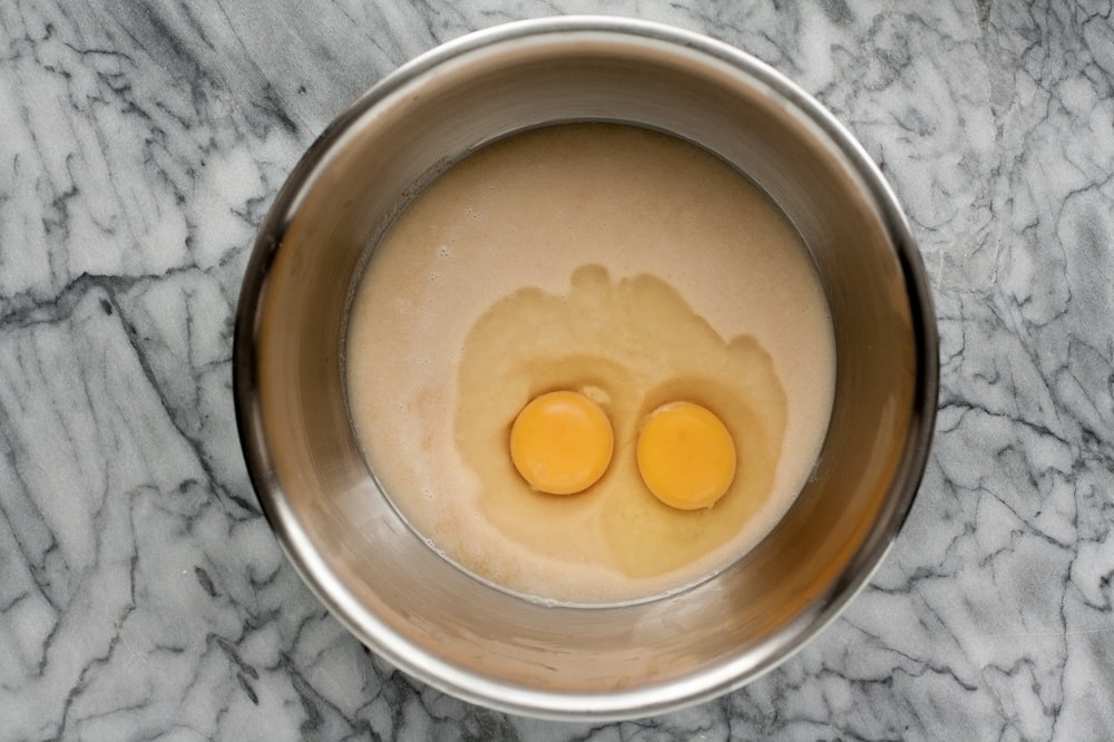ingredients-mixed-with-eggs-on-top-for-Low-Carb-Coconut-Blondies-in-stainless-steel-mixing-bowl-on-marble-board