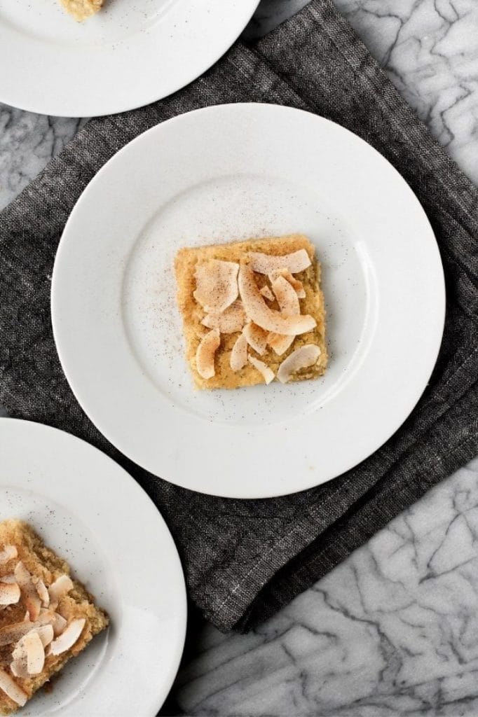 baked-Low-Carb-Coconut-Blondies-on-white-plates-on-top-of-table-napkin