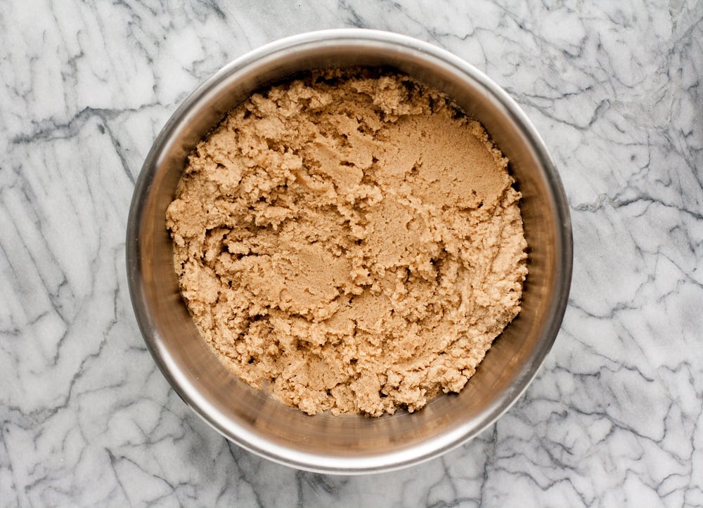 overhead-shot-of-mixture-with-dry-ingredients-in-stainless-steel-bowl-for-Cream-Cheese-Pumpkin-Muffins-on-marble-board