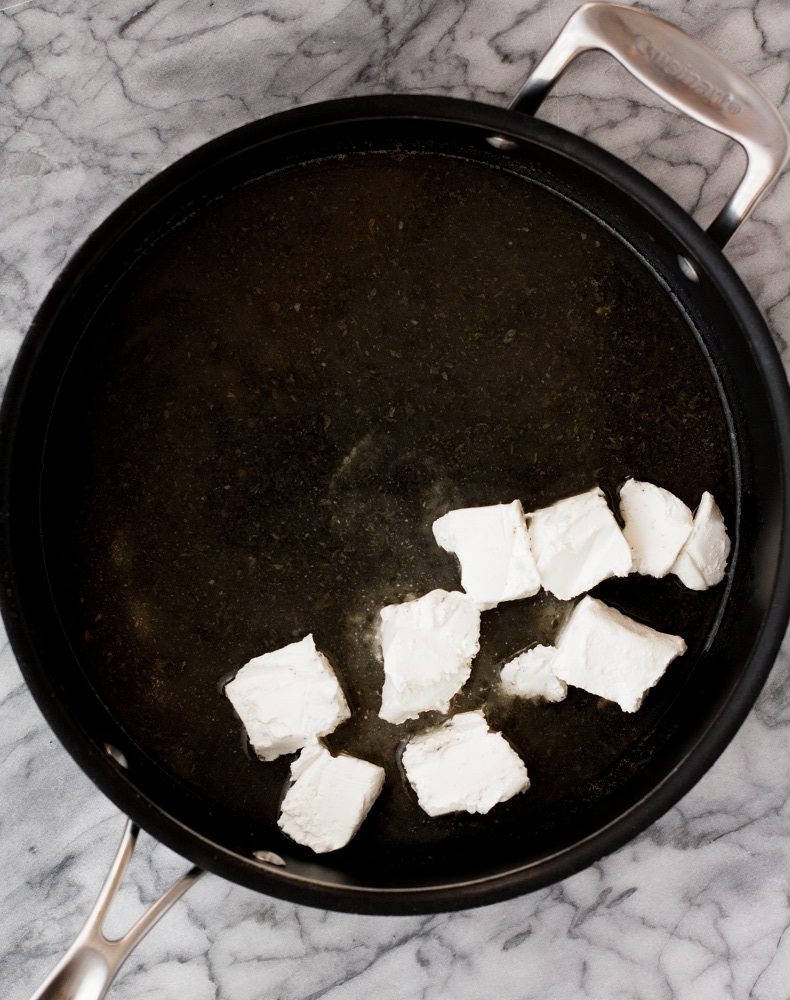 sauvignon blanc, reserved bacon fat, and dried parsley with cubed cream cheese in a large pot