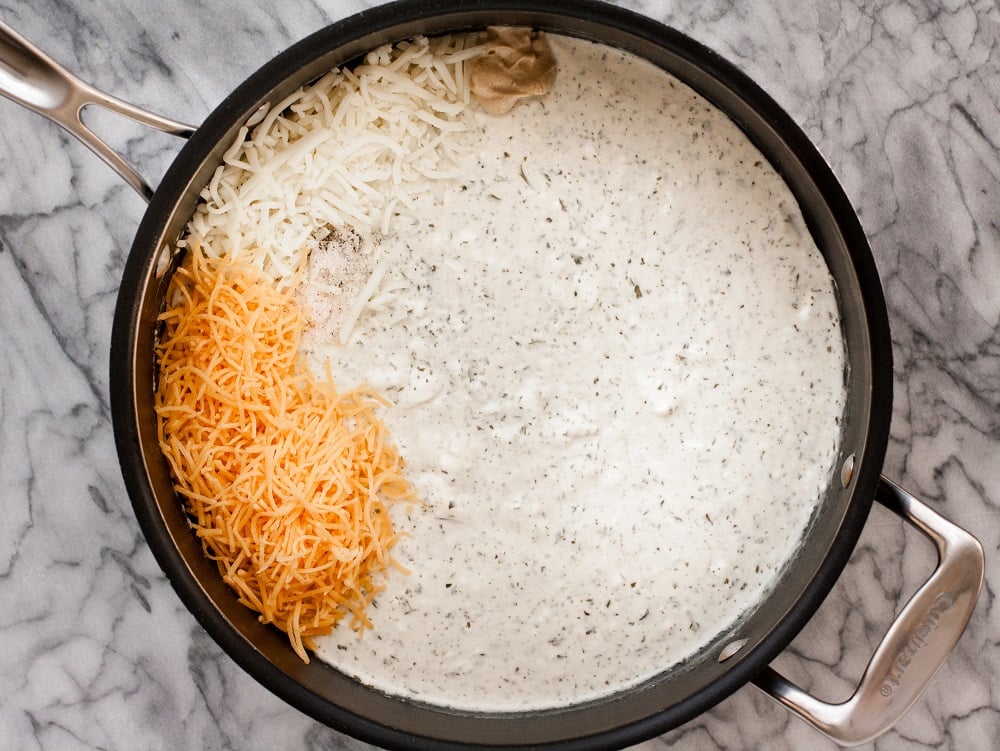 black-pot-with-cheese-sauce-and-shredded-cheese-on-marble-board-for-bacon-green-bean-casserole