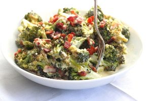 Keto Side Dish Recipes - roasted broccoli and bacon alfredo on a plate eaten with a fork
