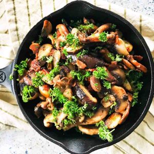 keto mushrooms with bacon cooked on a cast iron skillet