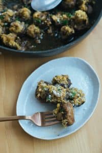 Keto Side Dish Recipes - parmesan garlic over roasted mushrooms on a light blue plate skewered by a fork