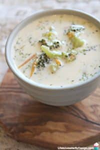 broccoli cheese soup cooked in the pressure cooker served in a ceramic bowl atop a wooden coaster