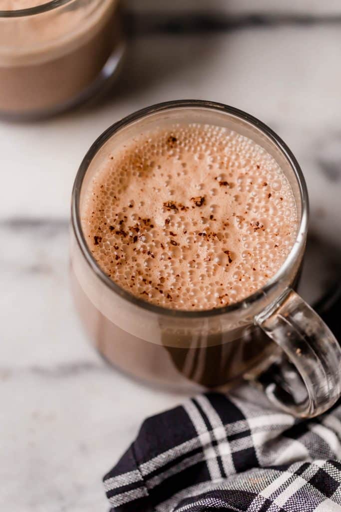 hero shot bulletproof peppermint mocha on top of a marble counter next to a black and white checkered linen napkin