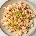 overhead image of a plate of cauliflower potato salad atop a marble kitchen counter