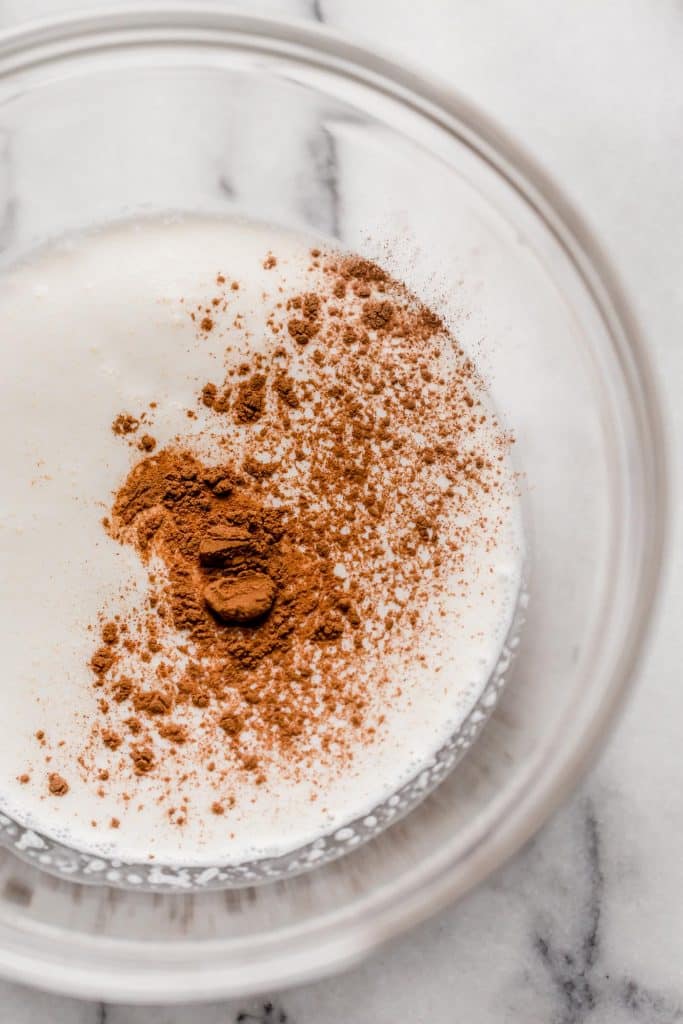 heavy cream vanilla extract in a mixing bowl on top of a marble counter