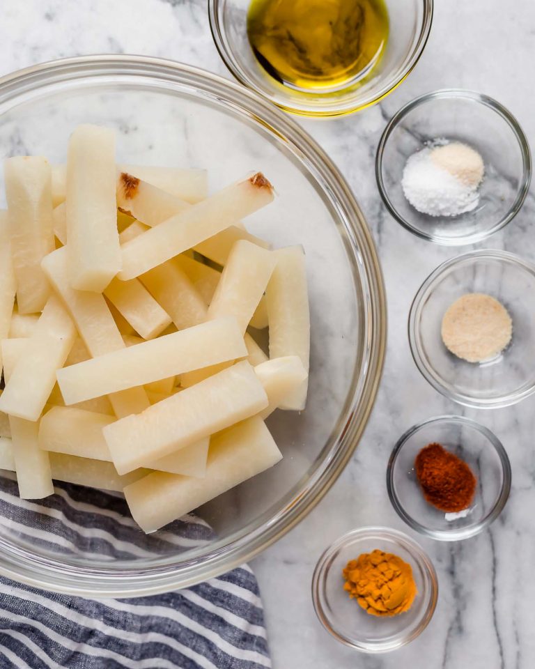 jicama fries in a large mixing bowl along with smaller bowls of spices