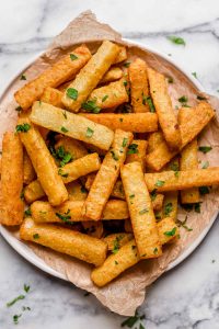 Golden Jicama Fries on a plate atop of a table