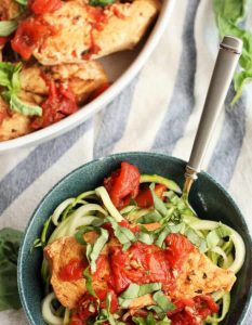 bruschetta chicken served on a teal colored ceramic bowl and fork