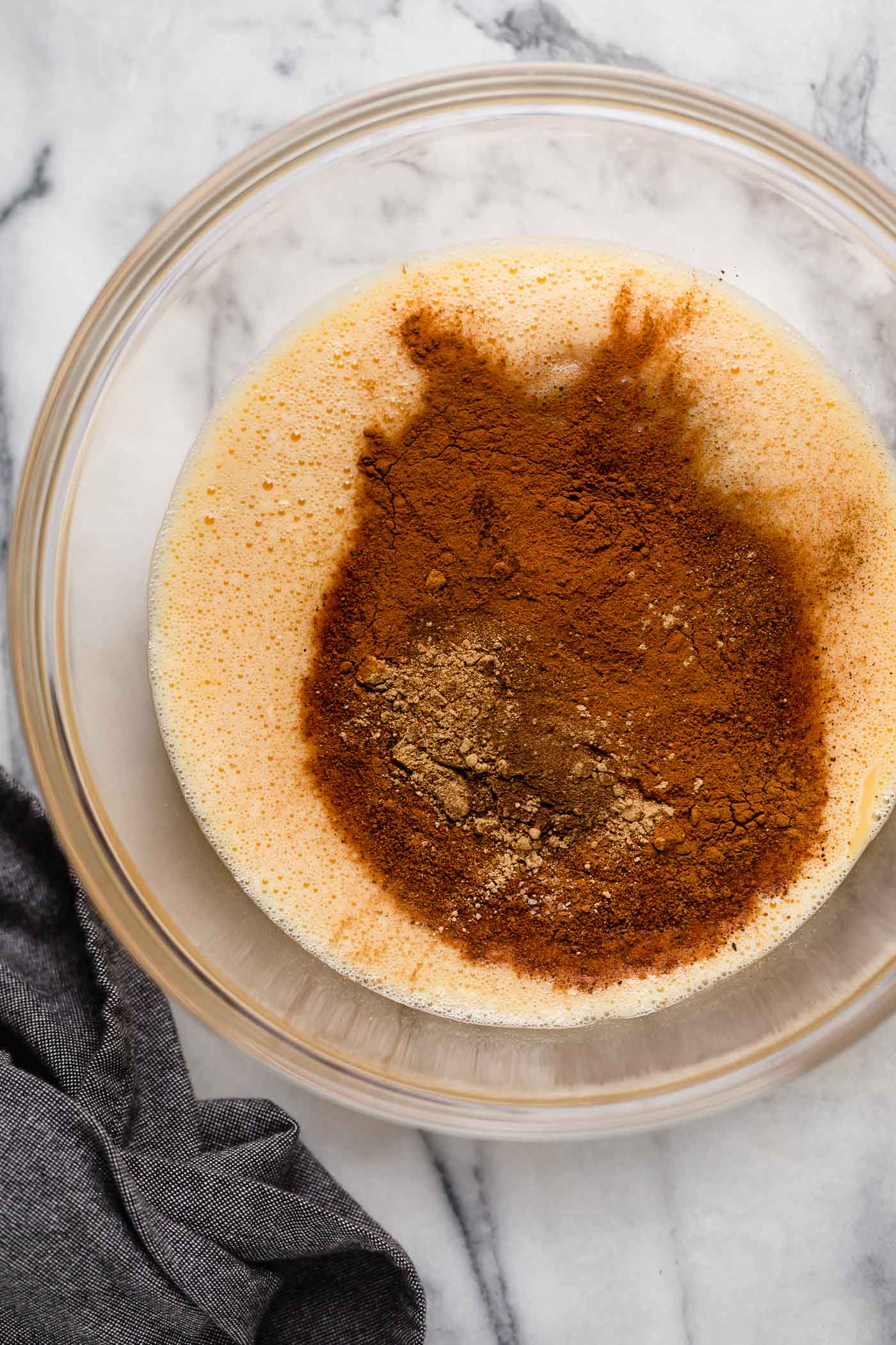 egg mixture in a large bowl with ground nutmeg, ground ginger, salt, ground allspice, and ground cloves
