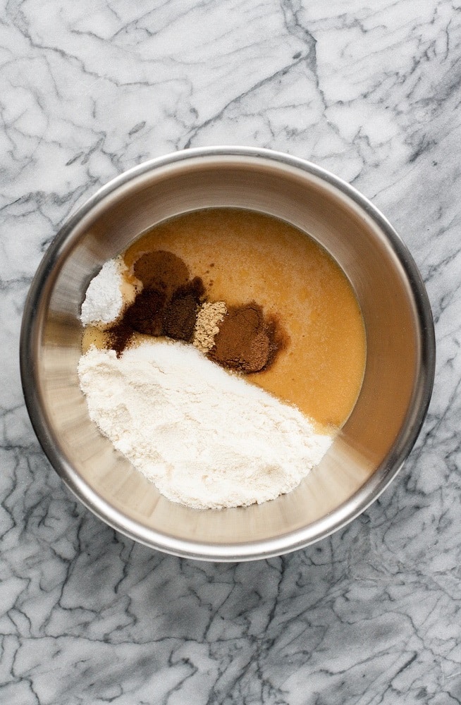 eggs and pumpkin puree mixed, coconut flour and other spices in a stainless steel bowl on marble board