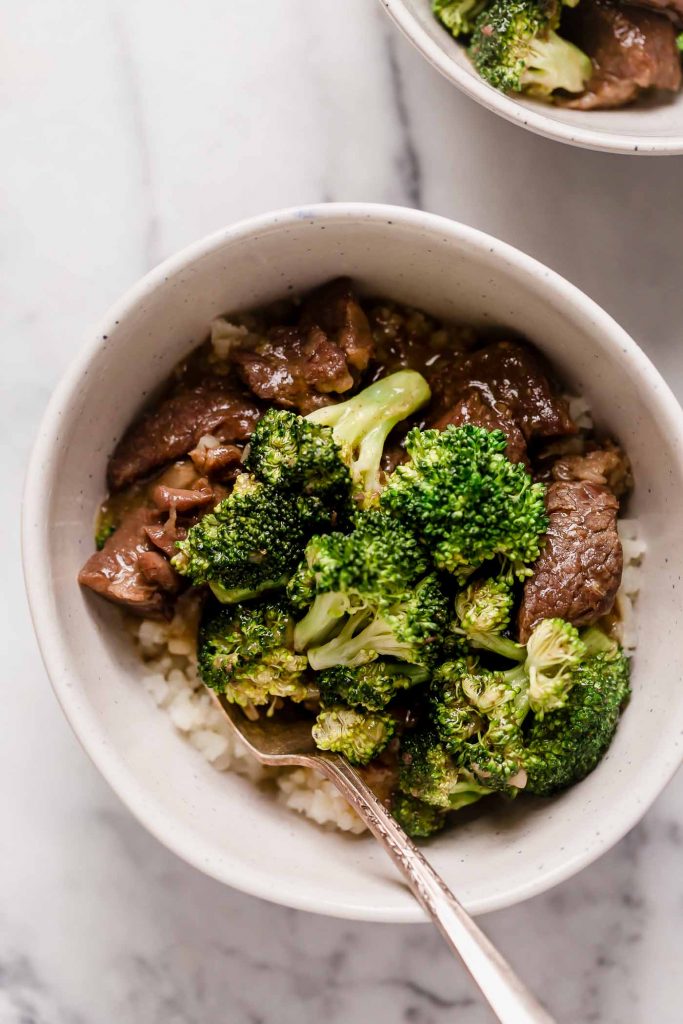 instant pot beef broccoli and rice in a ceramic bowl with a spoon