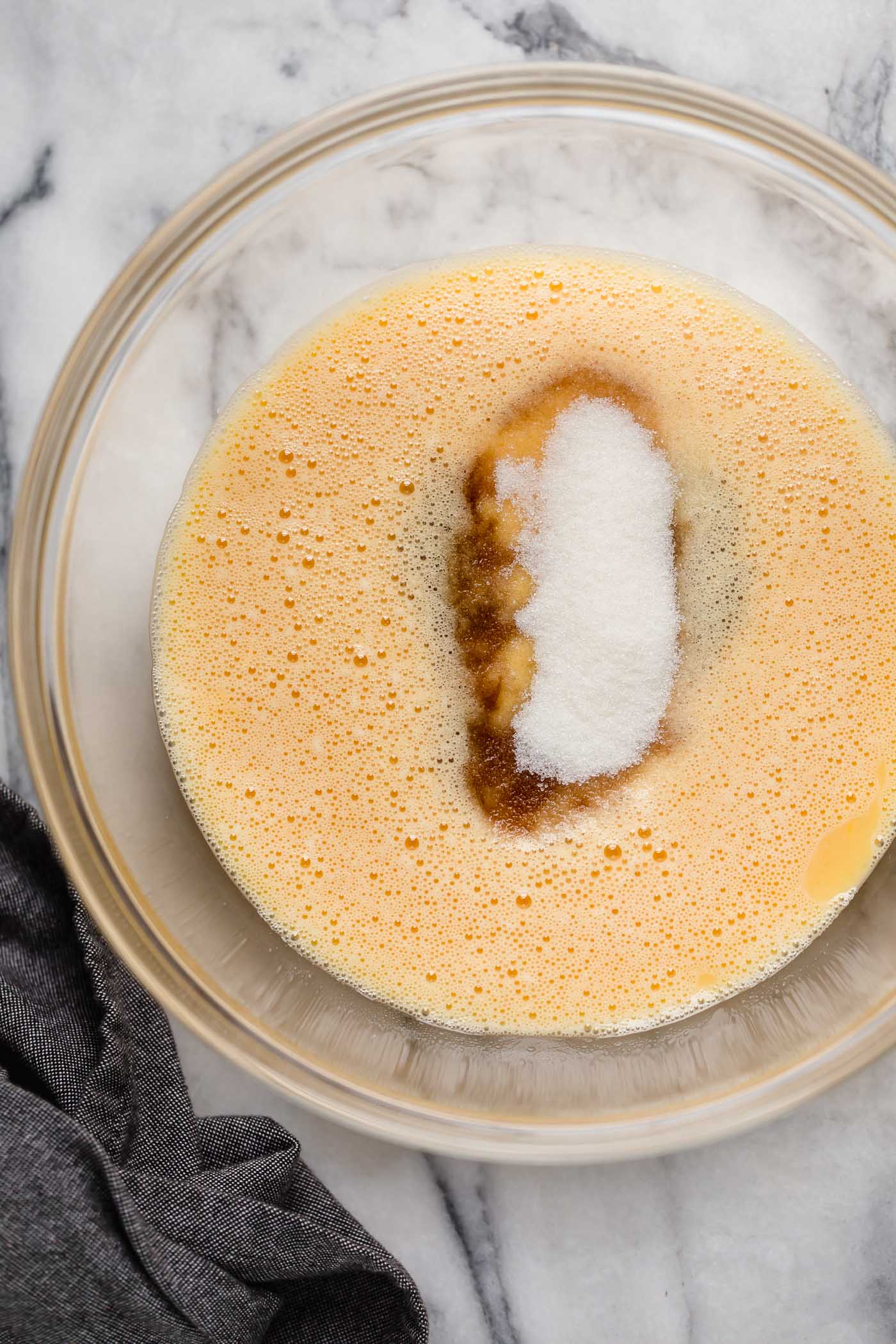 large bowl of egg mixture with vanilla extract, monk fruit sweetener, cinnamon, cream of tartar