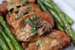 instant pot smothered pork chops with asparagus on a plate