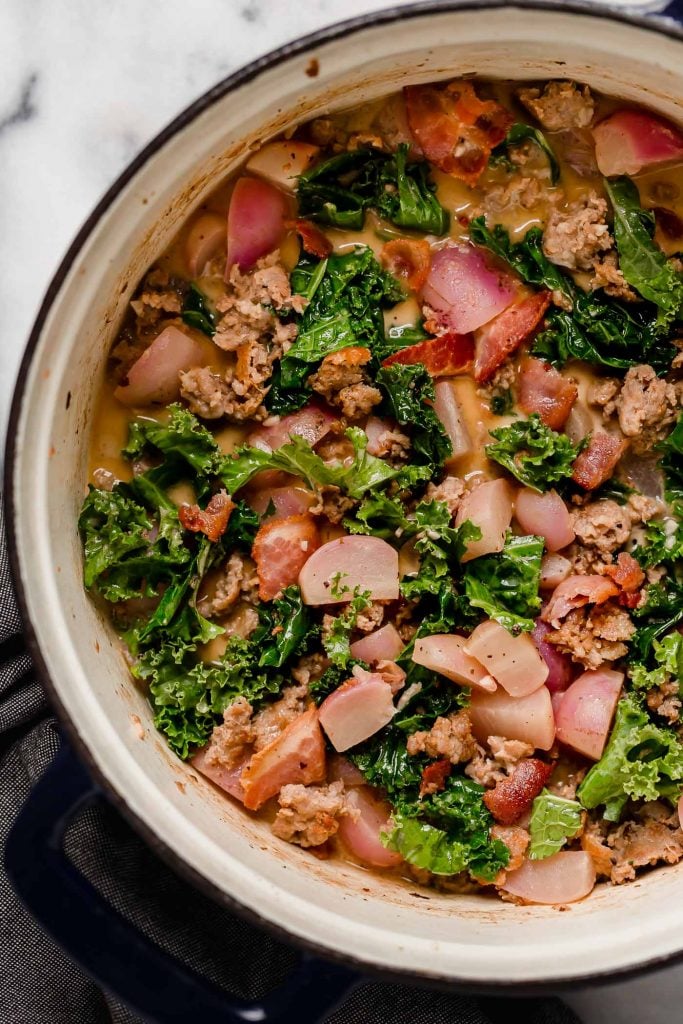 simmered soup mixed in with chopped kale and browned sausage