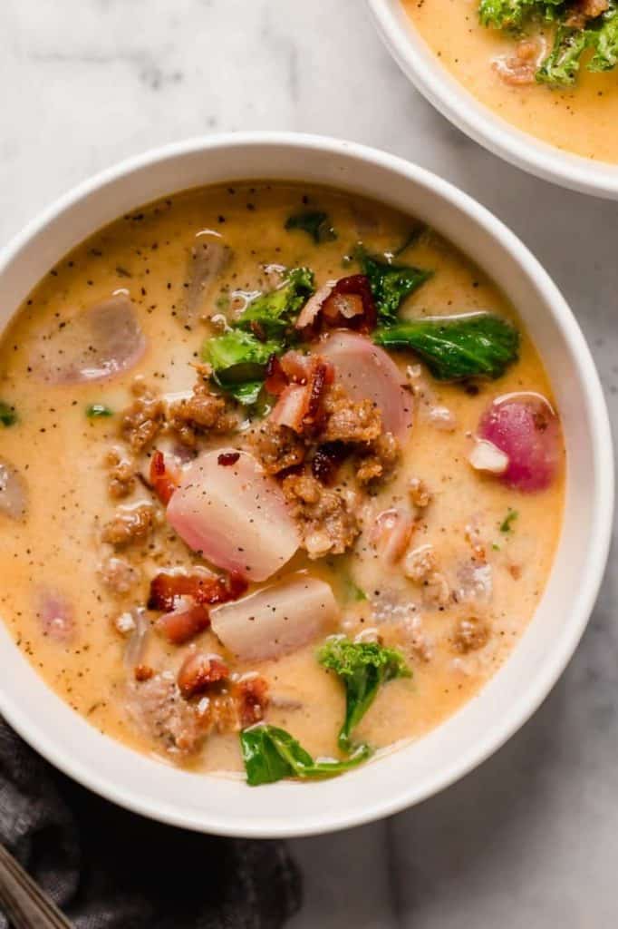 hero shot a bowl of keto zuppa toscana on top of a marble kitchen counter