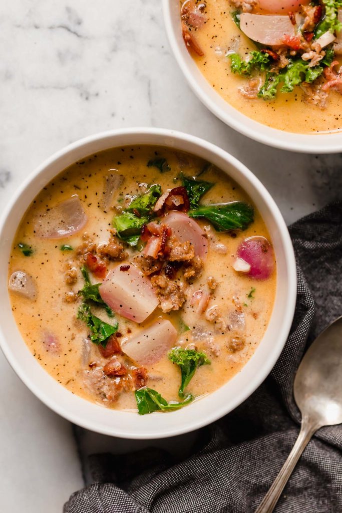 two bowls of keto zuppa toscana beside a spoon