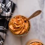 single low carb pumpkin mousse serving with a spoon on top of a marble kitchen counter