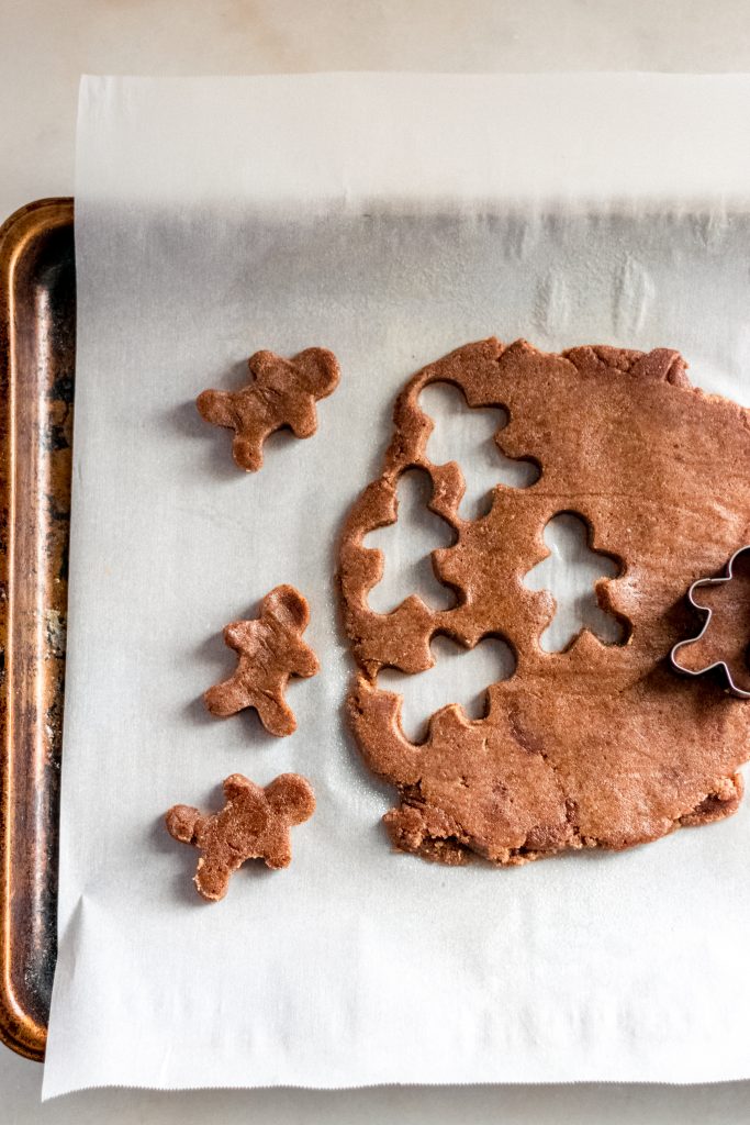 keto gingerbread cookie dough cut into gingerbreadmen shapes using a cookie cutter