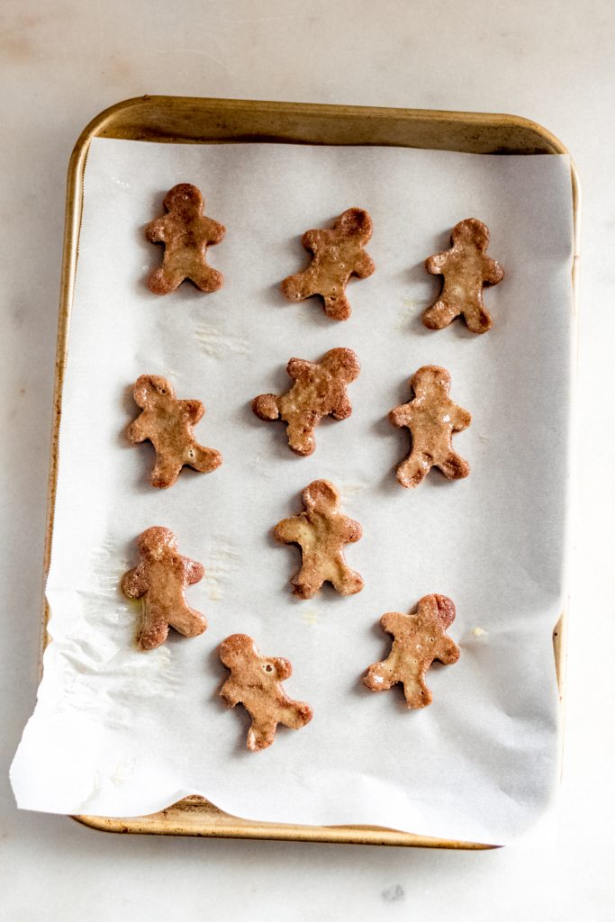 half baked gingerbreadmen on a baking sheet lined with parchment paper and brushed with egg wash