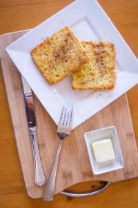 Keto French toast on square plate with silverware and butter