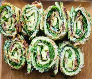 7 Bacon, Basil, & Greens Egg Roll-ups on a wooden surface