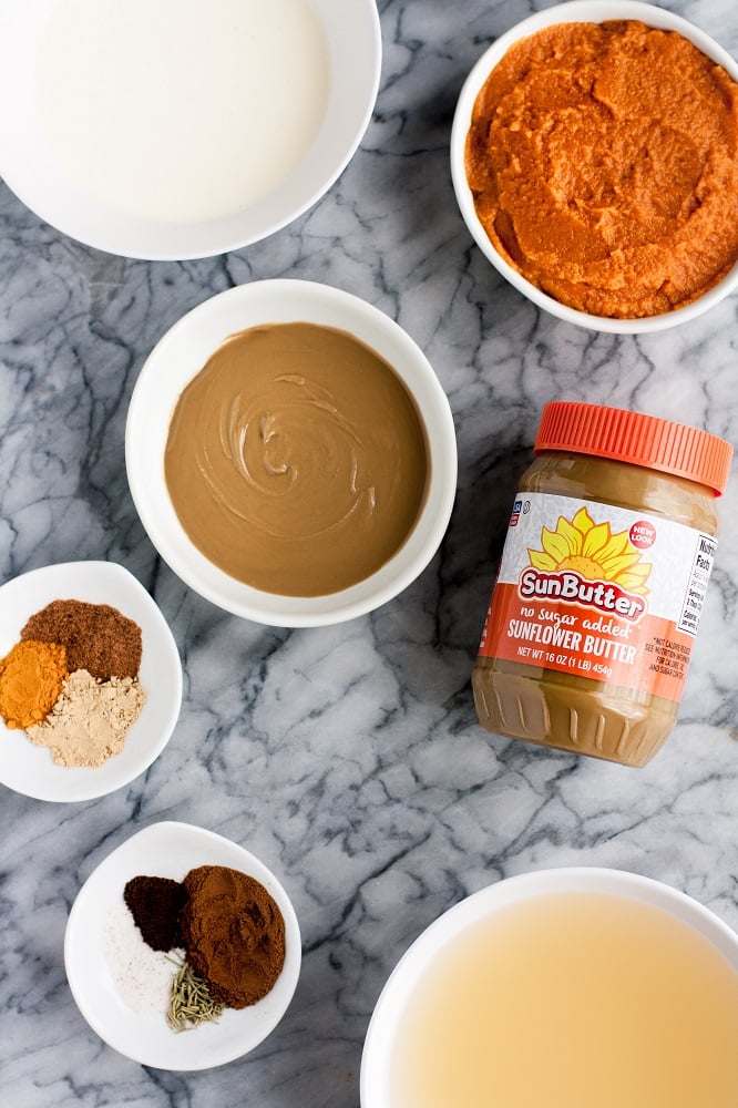real balanced pumpkin sunbutter soup ingredients neatly laid on top of a marble kitchen counter