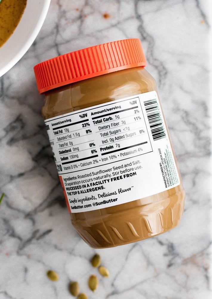 a jar of SunButter's no sugar added sunflower butter on top of a marble counter with nutritional label facing up