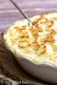 keto mashed cauliflower with cream cheese & asiago baked in a dish