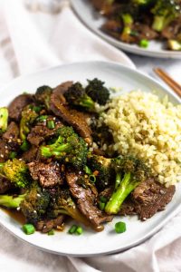 White plate with Paleo Beef and Broccoli Stir Fry with cauliflower rice