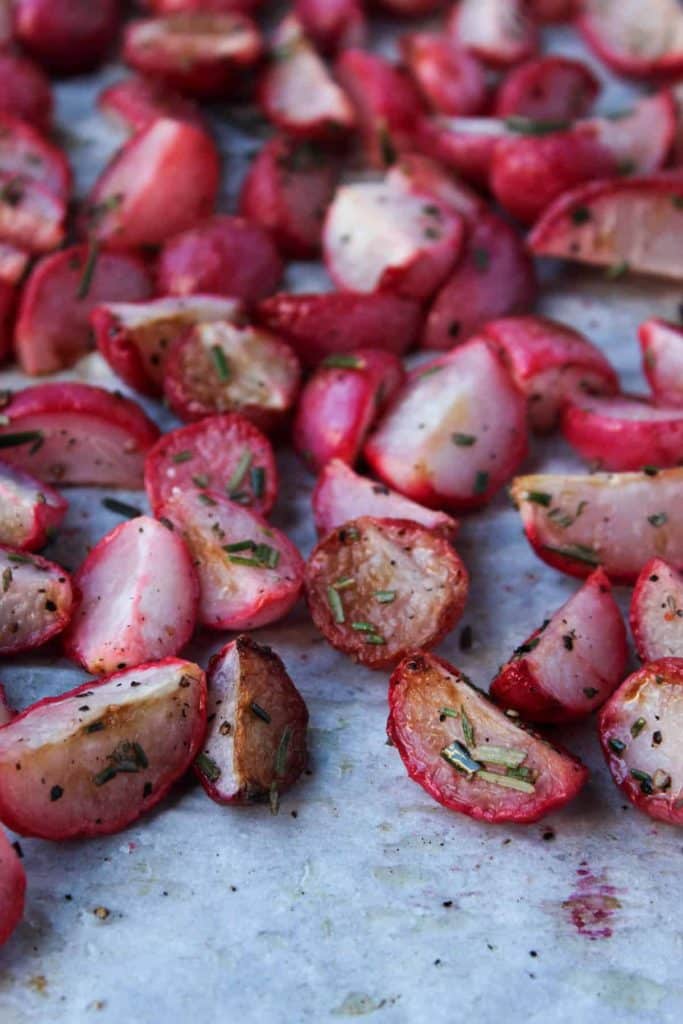 Closeup of rosemary roasted radishes on parchment paper