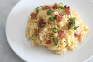 serving of cheesy cheddar cauliflower rice on a plate