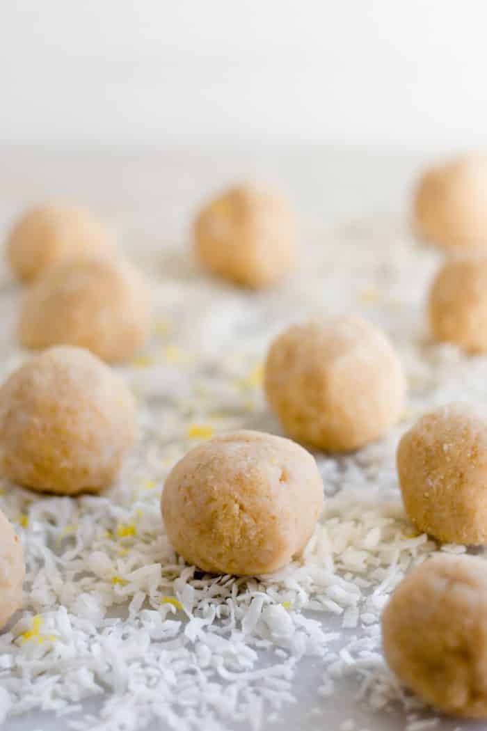 ten lemon bar fat bombs that have been rolled into bite-sized balls