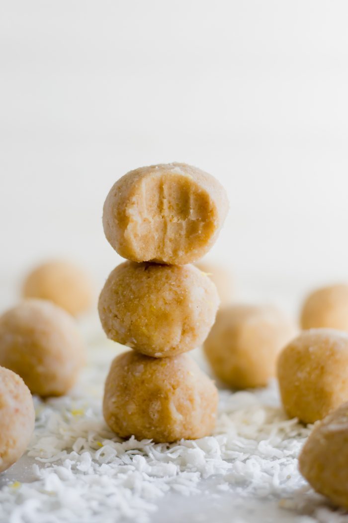 a stack of lemon bar fat bombs with the top being a half-bit fat bomb
