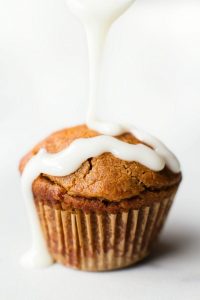 Low Carb Cinnamon Roll Muffin with icing being drizzled on it