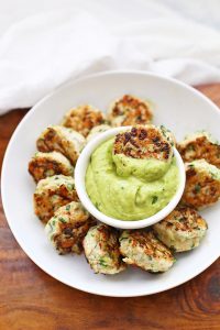 Plate of Chicken Zucchini Poppers with green avocado sauce