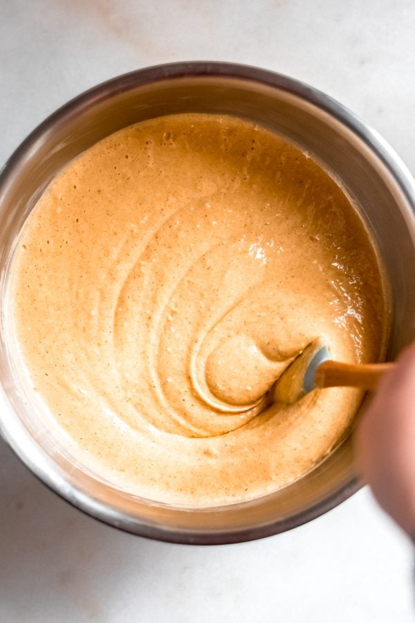 pumpkin cheesecake batter mixed in a stainless steel mixing bowl