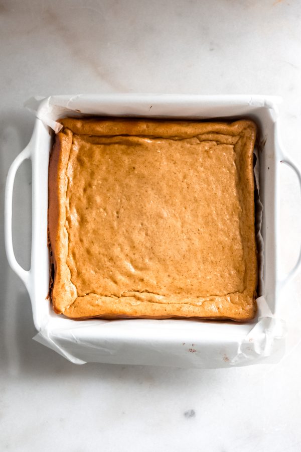 baked pumpkin cheesecake in a square ceramic baking pan