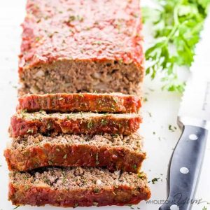 sliced Paleo Keto Low Carb Meatloaf with knife and parsley