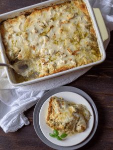 Dish of chicken pesto lasagna with one serving scooped on a plate