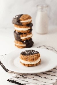 keto chocolate dipped peanut butter cookie sandwich on a plate with stack of 3 in the background